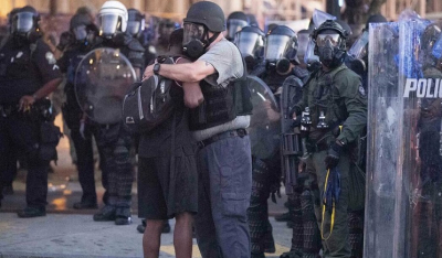 Η άλλη πλευρά: Αστυνομικοί αγκαλιάζουν και γονατίζουν μπροστά σε διαδηλωτές